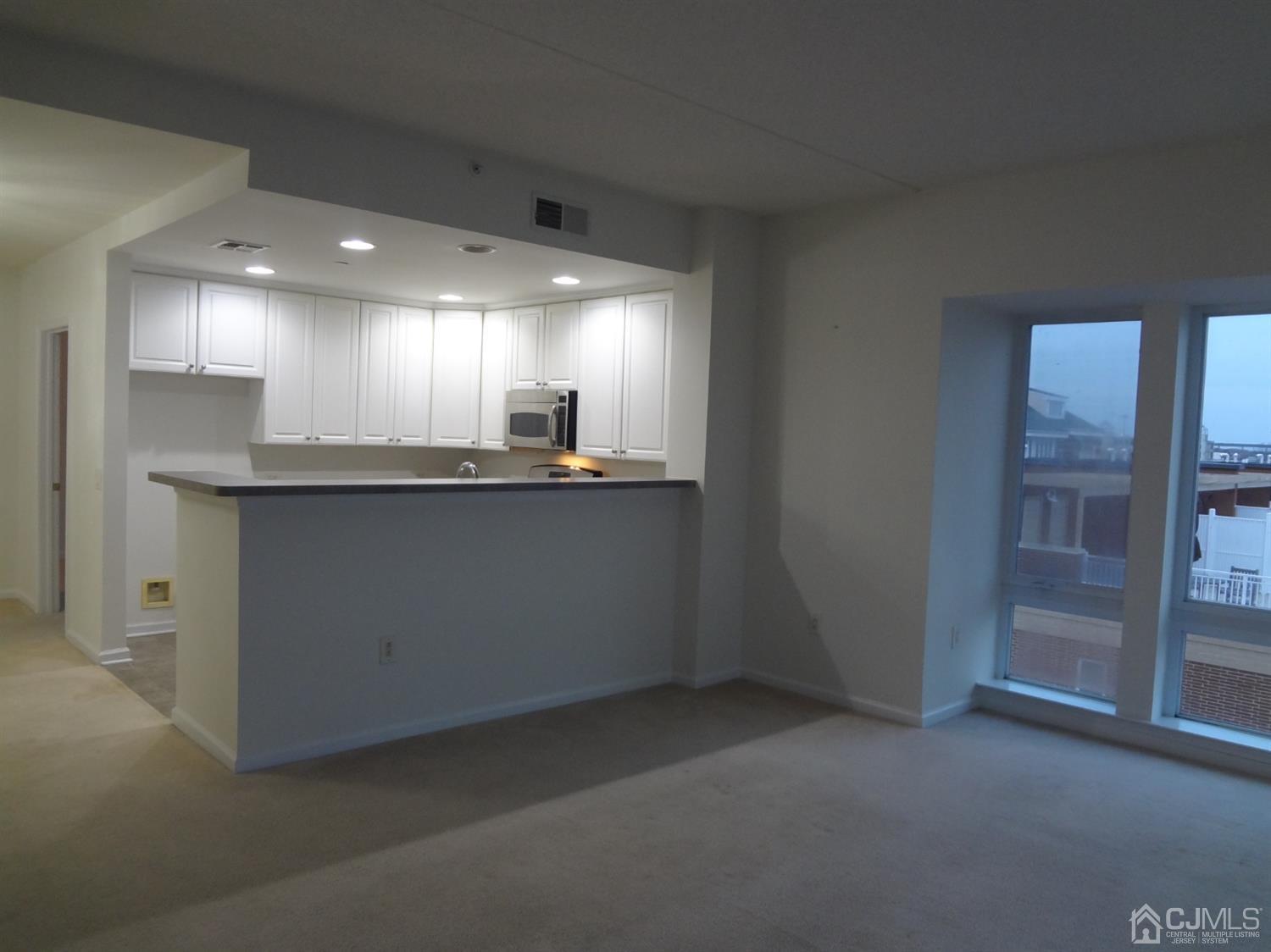 358 Rector Street, Unit 511 Perth Amboy, NJ 08861 - Photo 9 of 29 a kitchen with kitchen island a sink stainless steel appliances and cabinets