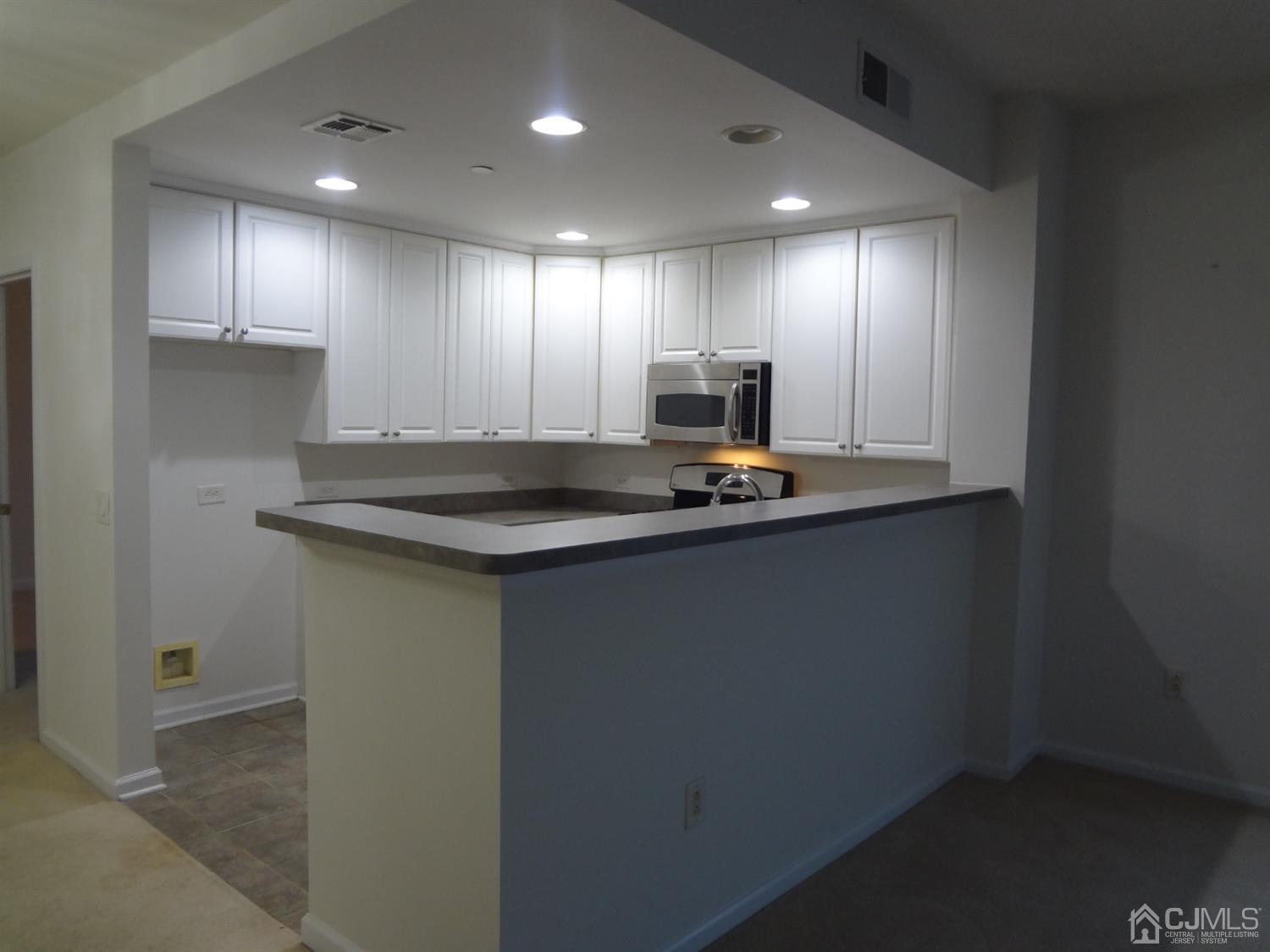 358 Rector Street, Unit 511 Perth Amboy, NJ 08861 - Photo 10 of 29 a kitchen with kitchen island granite countertop counter top space a sink and cabinets