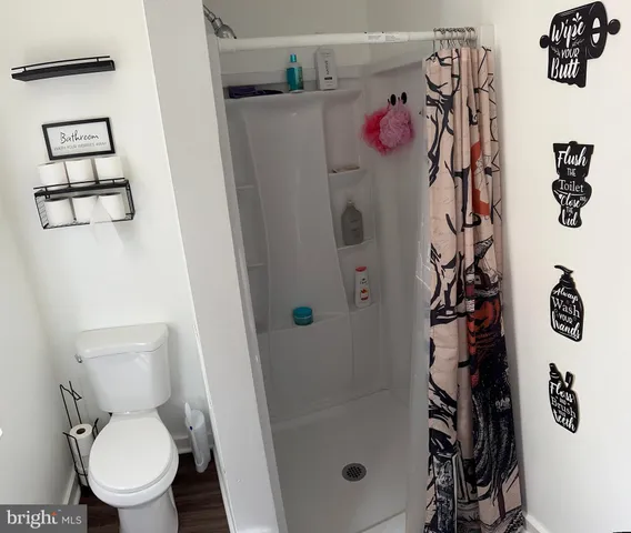 a bathroom with a toilet sink and shower curtain