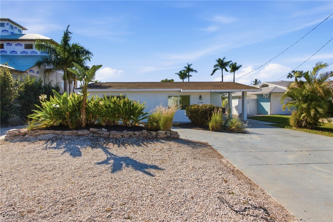 2754 Shoreview Drive Naples, FL 34112 - Photo 3 of 18 a front view of a house with garden