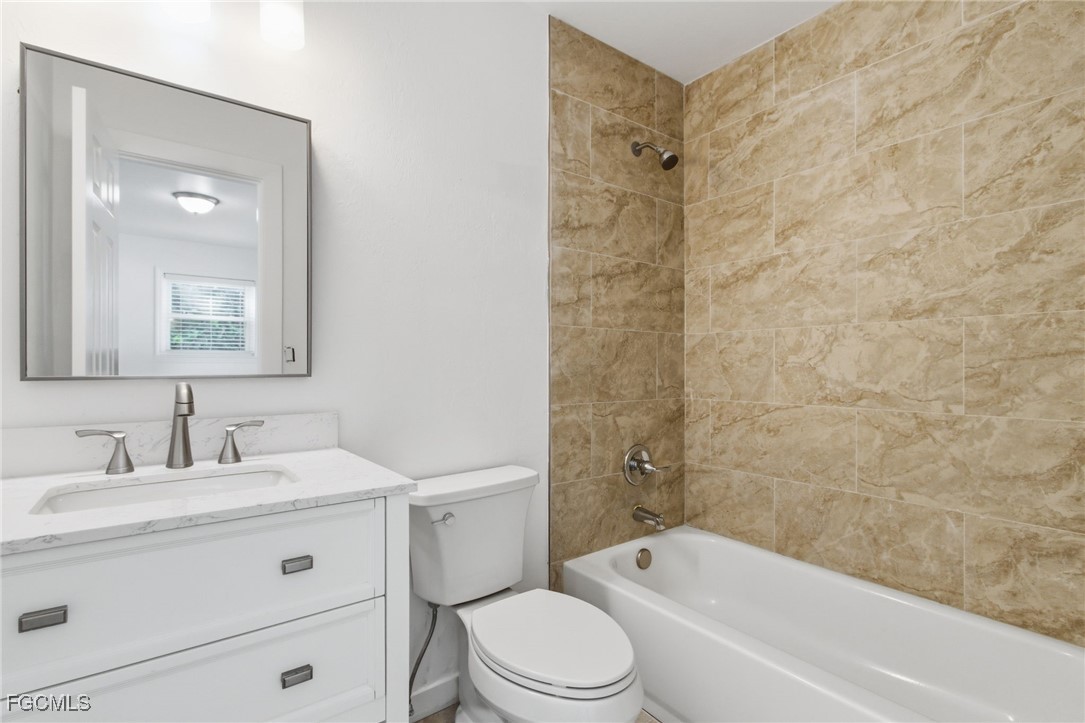 2754 Shoreview Drive Naples, FL 34112 - Photo 7 of 18 a bathroom with a granite countertop toilet a sink and a bathtub
