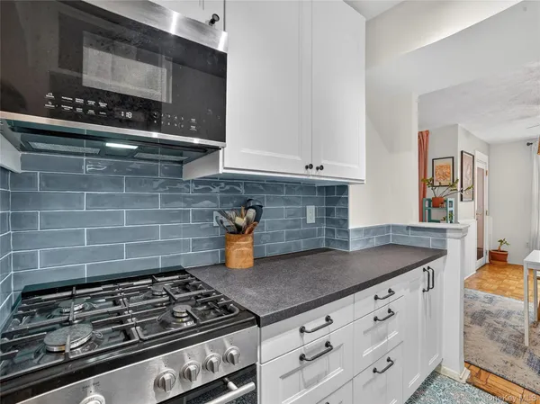 a kitchen with granite countertop a stove and cabinets