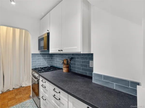 a kitchen with granite countertop white cabinets and white appliances