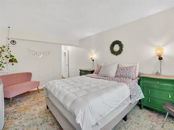 a large bed sitting in a bedroom next to a window and a larger closet
