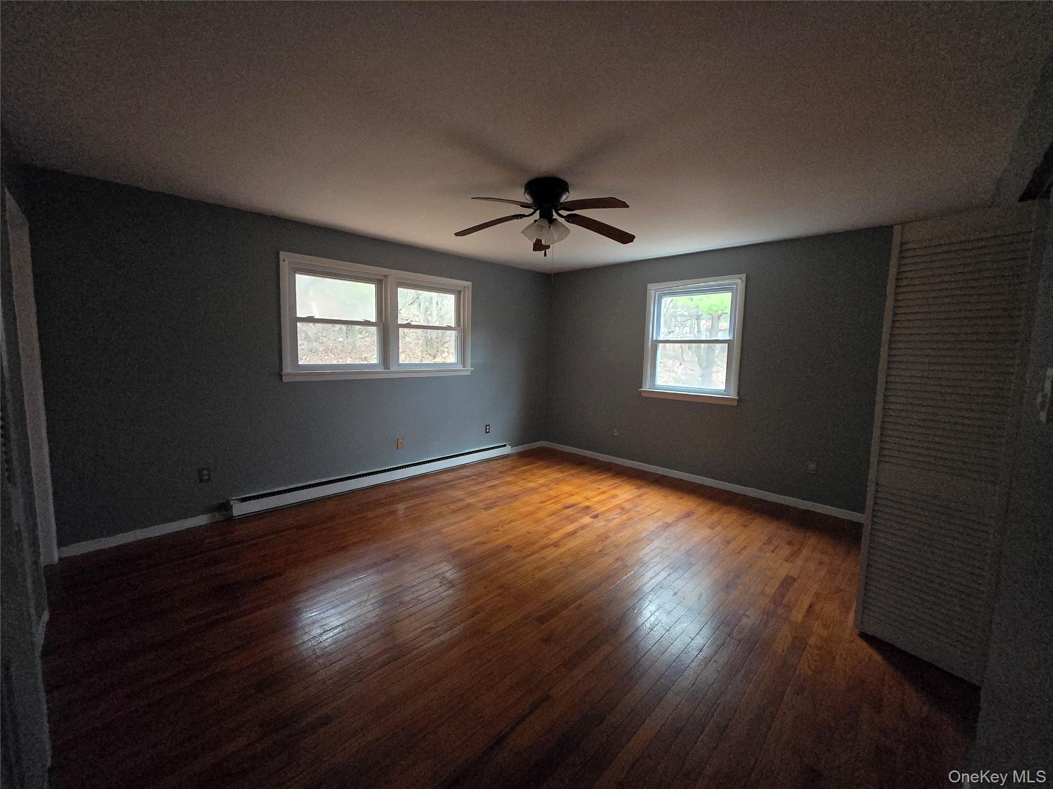 43 Glenmere Homesites Road Florida, NY 10921 - Photo 9 of 30 Unfurnished room with dark wood-style floors, a baseboard radiator, and ceiling fan