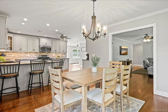 a view of a dining room and livingroom with furniture wooden floor a chandelier