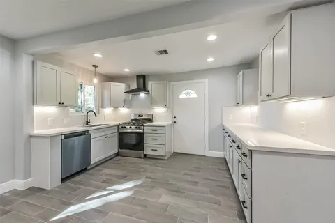 a kitchen with granite countertop a sink and white cabinets