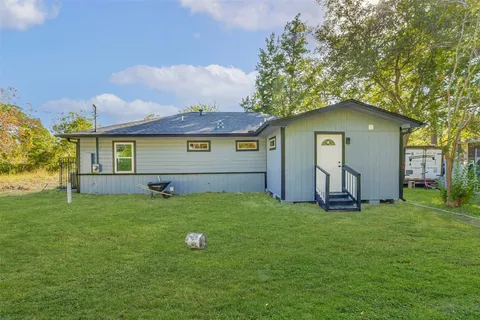 a house is sitting in middle od the grass