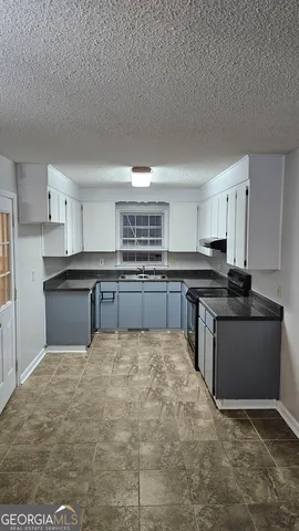 a large kitchen with kitchen island sink stove and refrigerator
