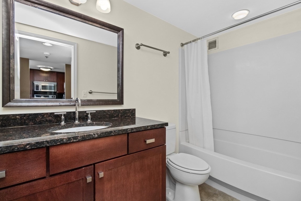 10 Museum Way, Unit 1322 Cambridge, MA 02141 - Photo 13 of 30 a bathroom with a granite countertop sink toilet mirror and a bathtub