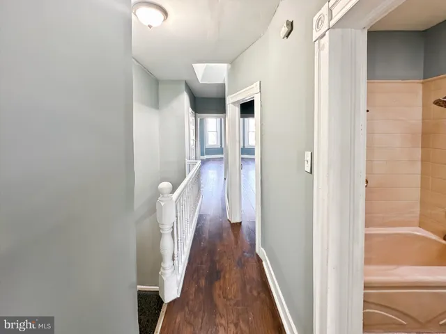 a view of a hallway with wooden floor