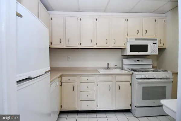 a kitchen with granite countertop white cabinets and a stove