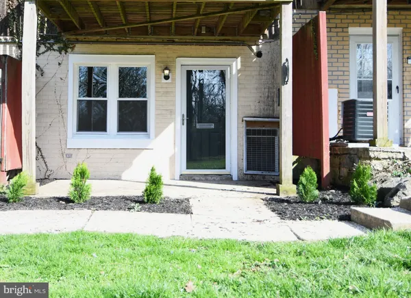 a front view of a house with a yard and potted plants