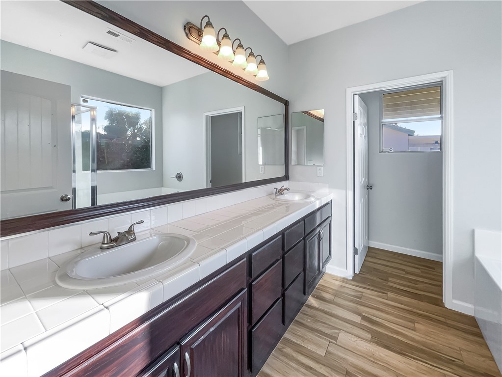 3429 Catalina Avenue Hemet, CA 92545 - Photo 6 of 20 a spacious bathroom with double vanity and a mirror