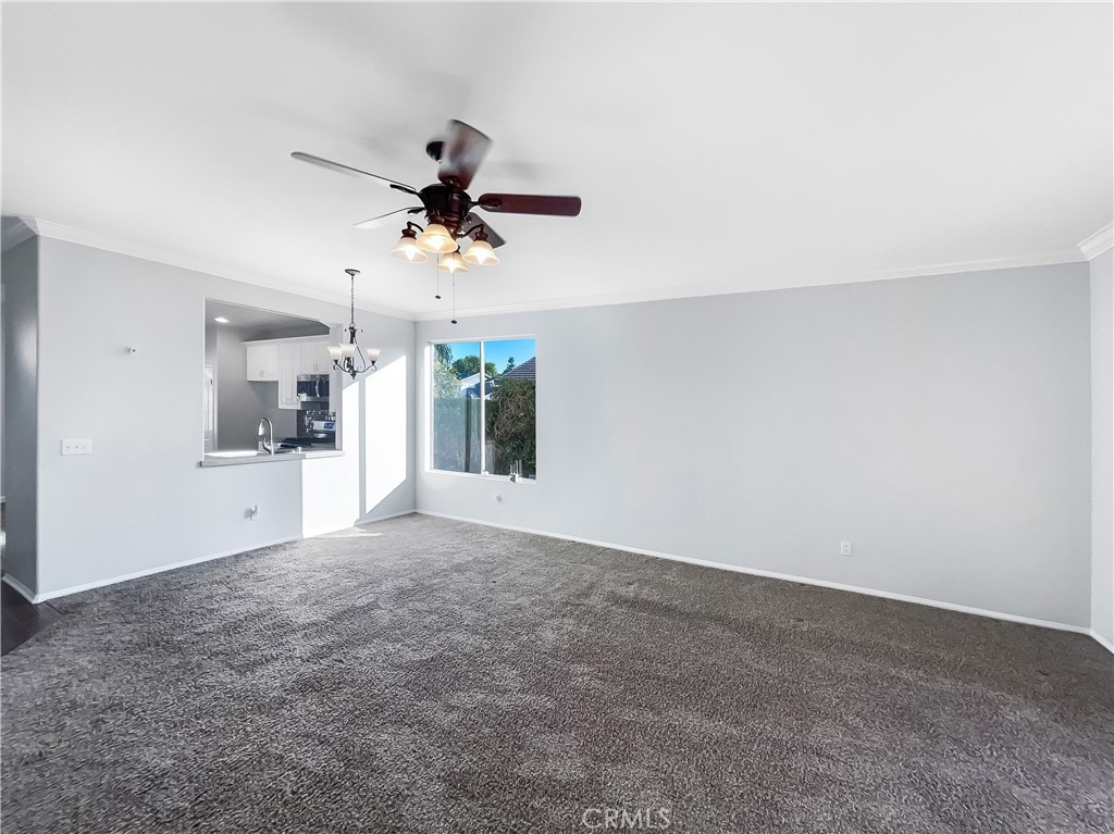 3429 Catalina Avenue Hemet, CA 92545 - Photo 8 of 20 a view of a kitchen with an empty space and a ceiling fan