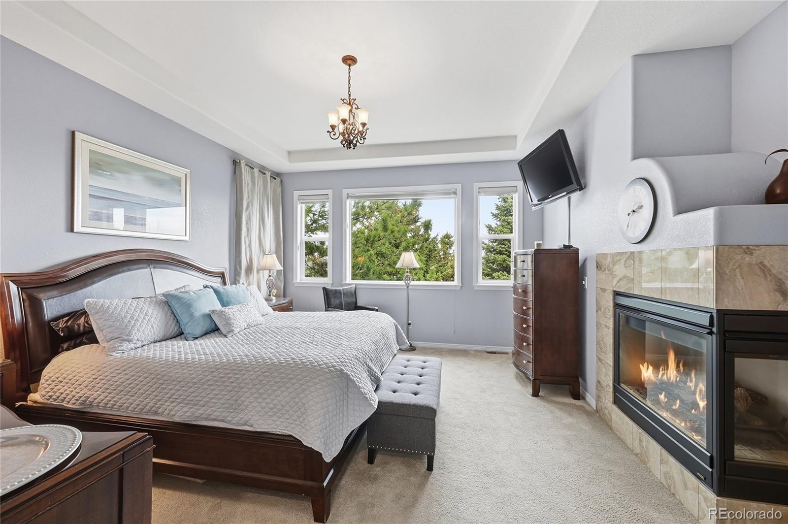 2626 Pemberly Avenue Highlands Ranch, CO 80126 - Photo 19 of 49 a bedroom with a bed fireplace and window
