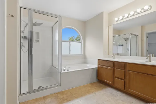 a spacious bathroom with a tub sink shower and mirror