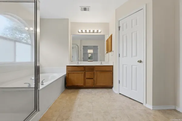 a bathroom with a tub sink and mirror