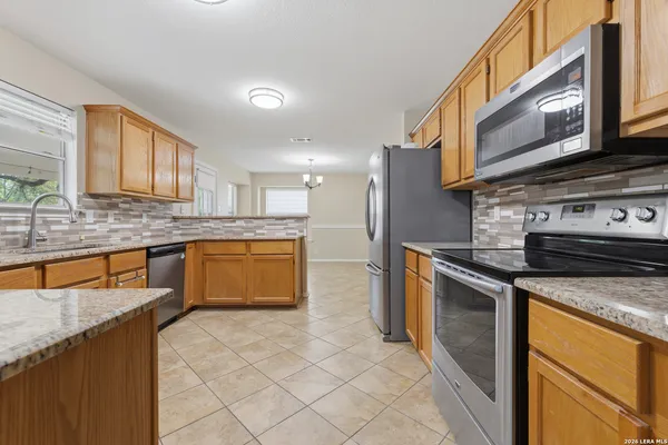 a kitchen with stainless steel appliances granite countertop a stove a sink and a microwave
