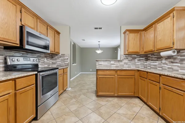 a kitchen with stainless steel appliances granite countertop a sink stove and microwave