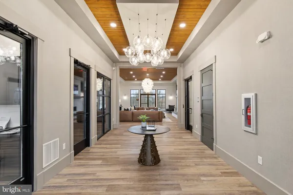 a view of a hallway view with wooden floor and chandelier