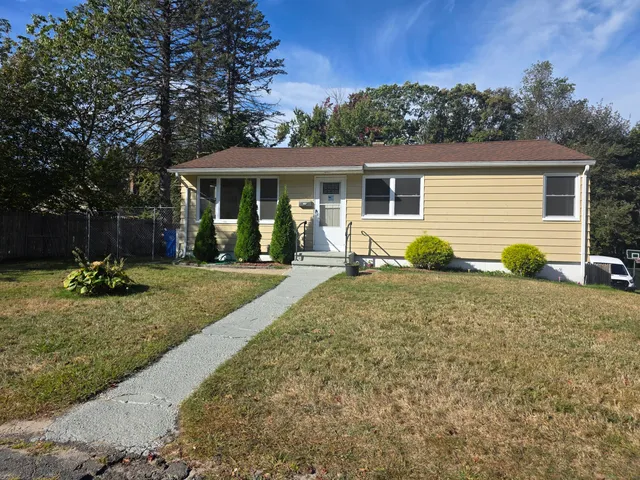 a view of a house with backyard and trees