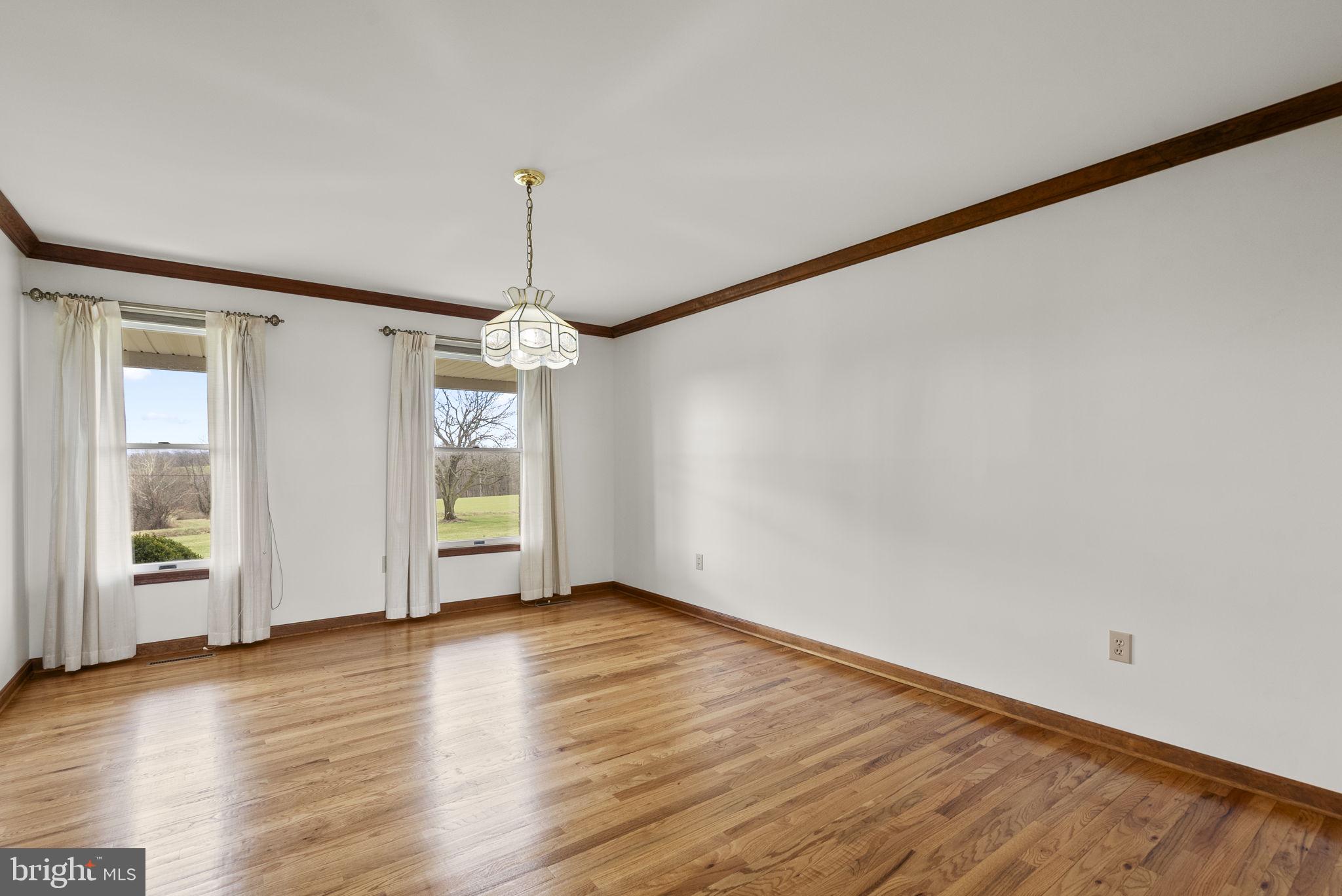 9224 Ball Road Ijamsville, MD 21754 - Photo 13 of 56 a view of an empty room with wooden floor and a window