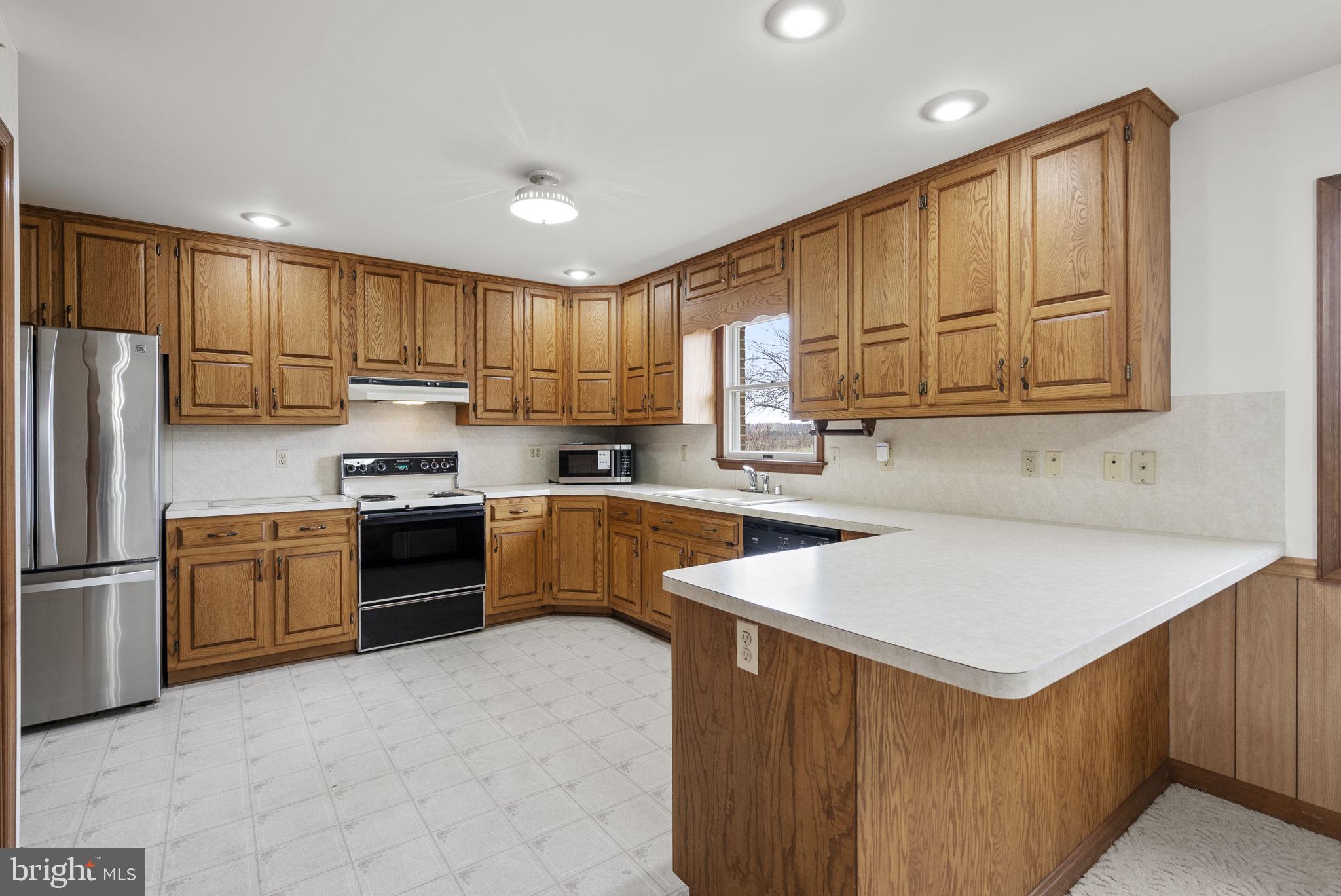 9224 Ball Road Ijamsville, MD 21754 - Photo 18 of 56 a kitchen with stainless steel appliances granite countertop a refrigerator sink stove microwave and cabinets