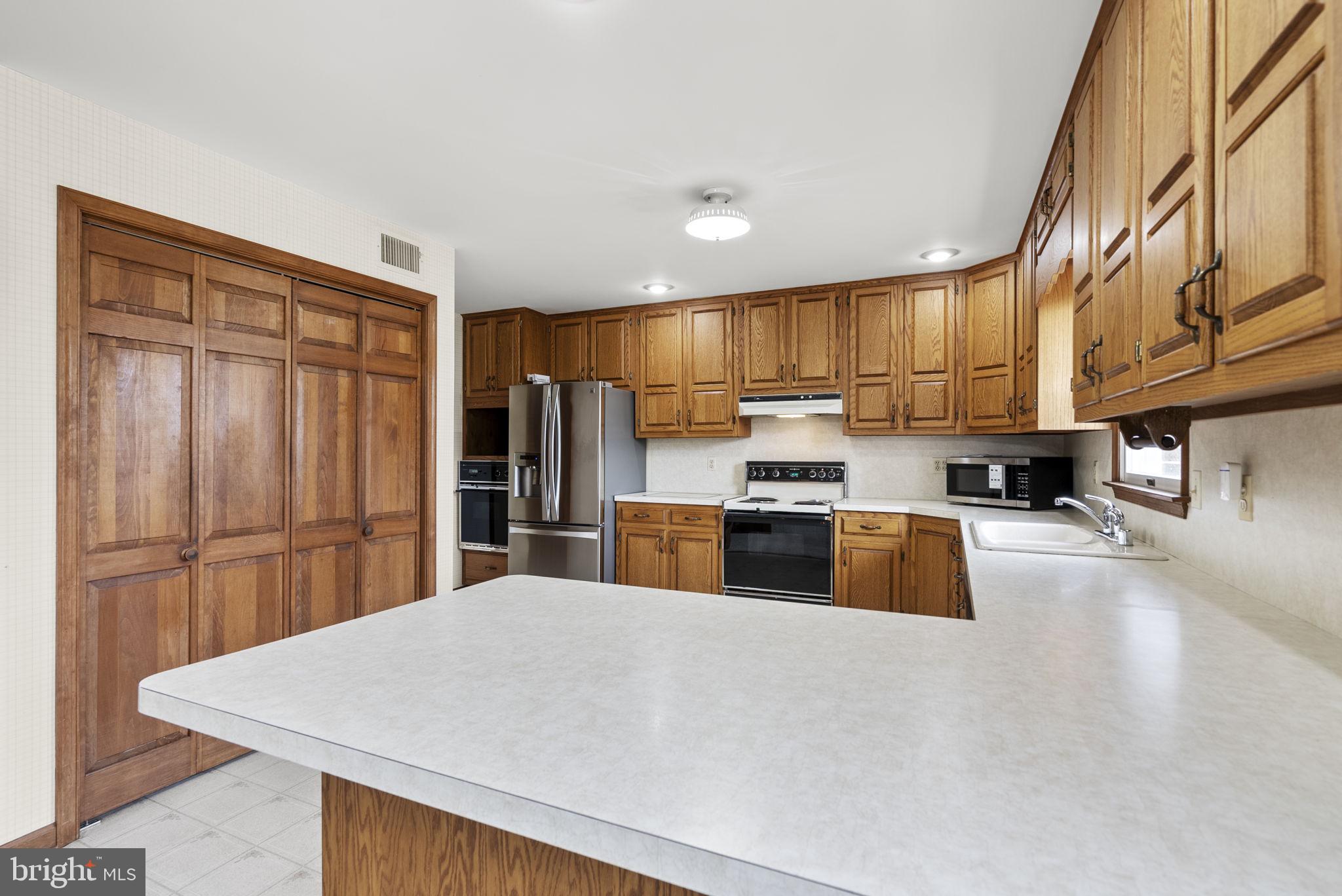9224 Ball Road Ijamsville, MD 21754 - Photo 19 of 56 a kitchen with stainless steel appliances granite countertop a refrigerator a sink dishwasher a stove and a refrigerator with wooden floor