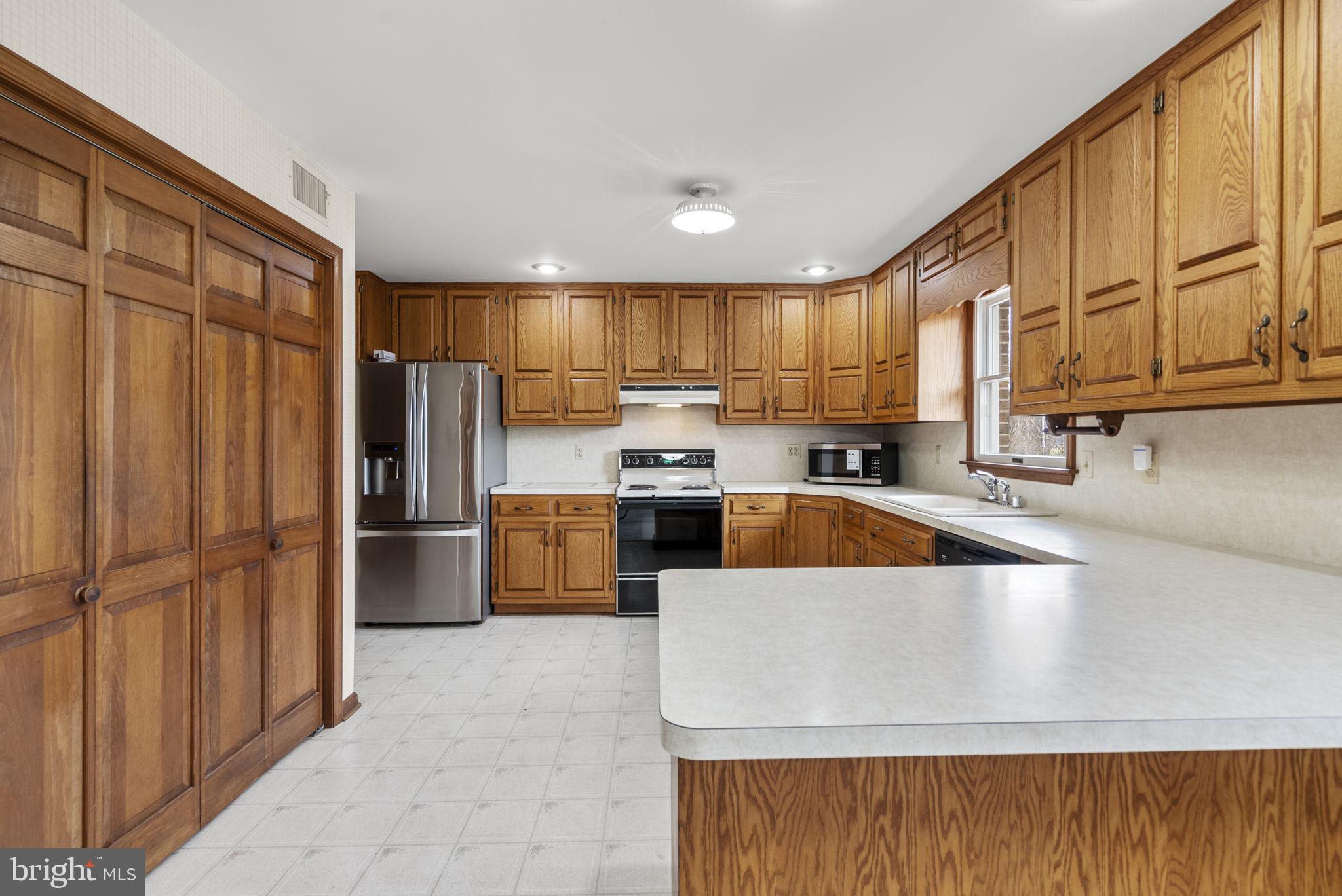 9224 Ball Road Ijamsville, MD 21754 - Photo 5 of 56 a large kitchen with kitchen island a large counter top stainless steel appliances and cabinets