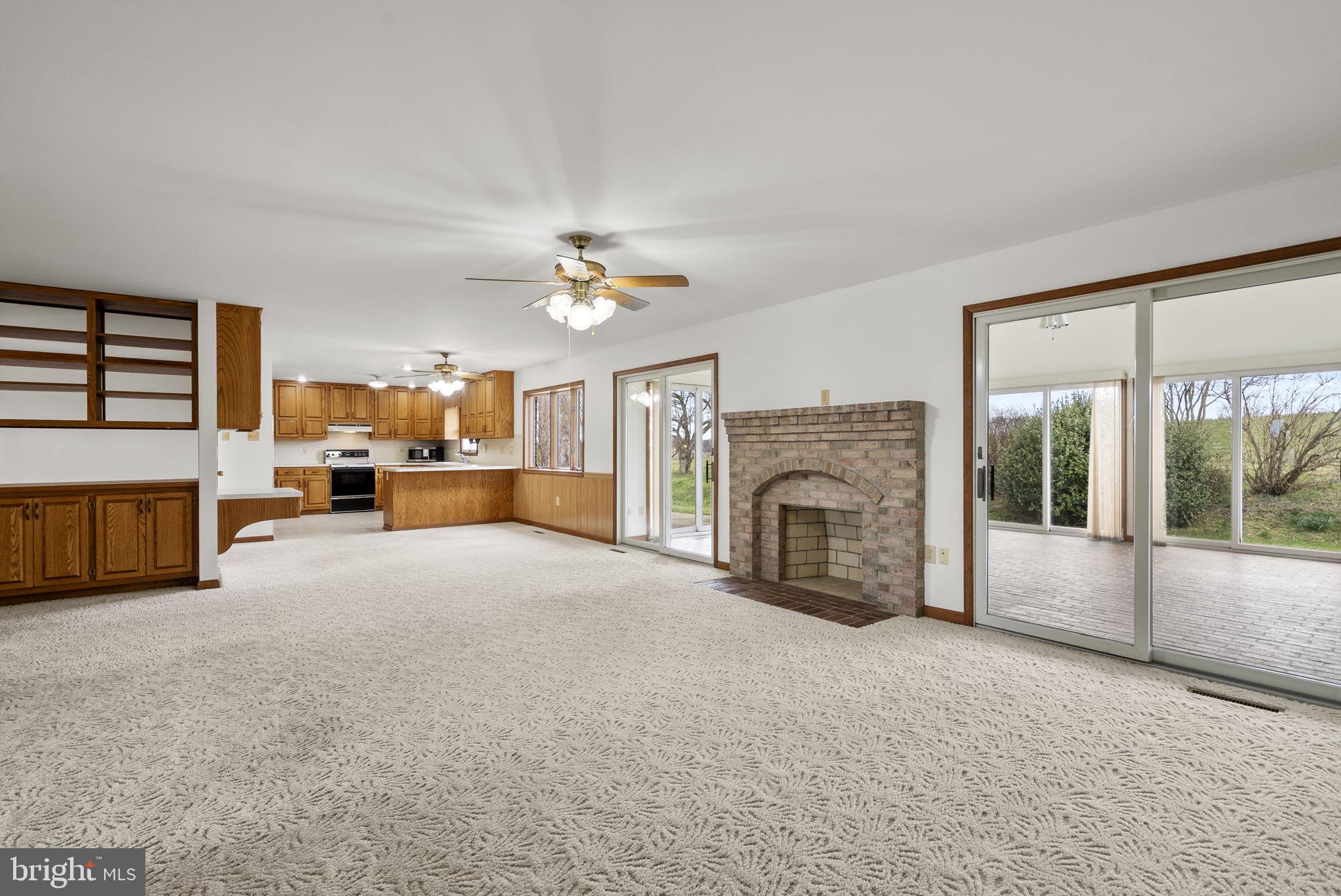 9224 Ball Road Ijamsville, MD 21754 - Photo 6 of 56 a view of a livingroom with a fireplace a ceiling fan a fireplace and windows