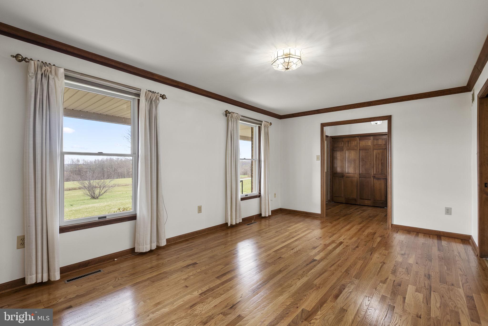 9224 Ball Road Ijamsville, MD 21754 - Photo 9 of 56 an empty room with wooden floor and windows