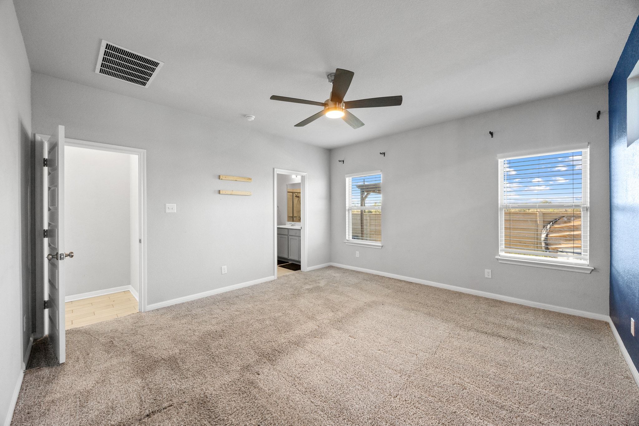 225 Unforgiven Lane Jarrell, TX 76537 - Photo 14 of 30 Unfurnished bedroom featuring light colored carpet, ensuite bath, and a ceiling fan