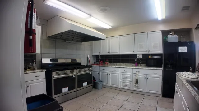 a kitchen with white cabinets and appliances