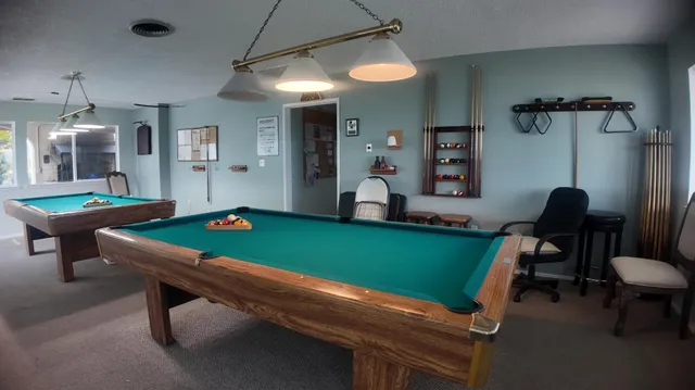 a room with pool table table soccer and windows