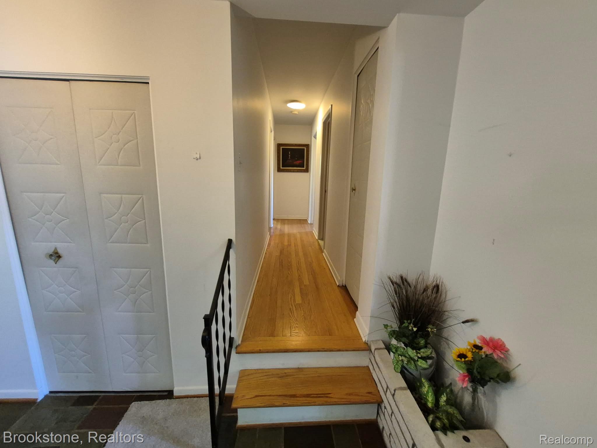 4295 Sashabaw Road Waterford, MI 48329 - Photo 11 of 37 Hardwood flooring extends through the hallway with white painted walls