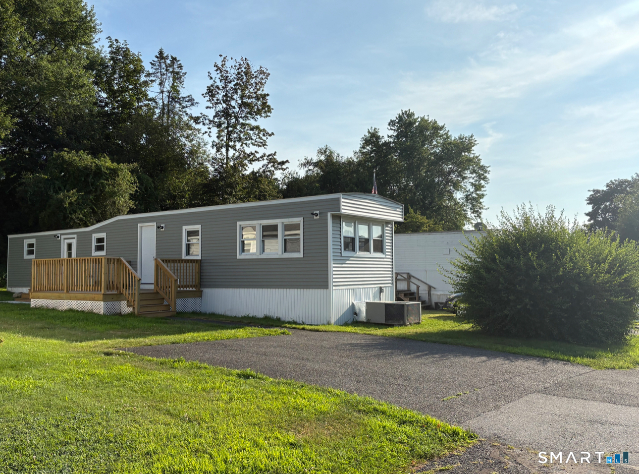 a front view of a house with a yard and trees