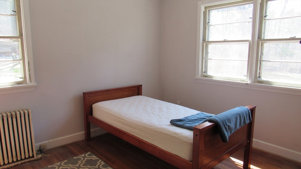 288 Linebrook Road Ipswich, MA 01938 - Photo 9 of 26 a bed sitting in a bedroom next to a window