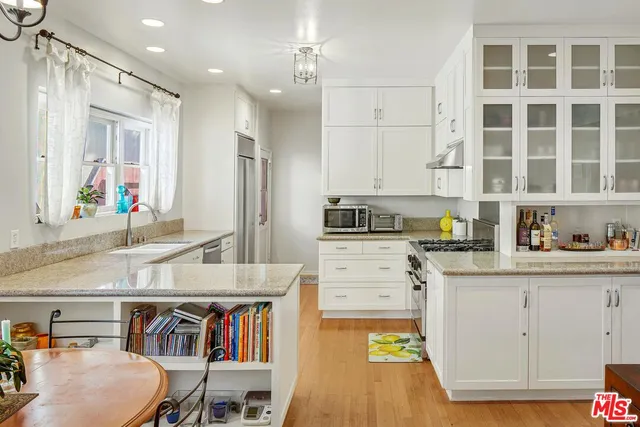 a kitchen with a refrigerator and a stove top oven