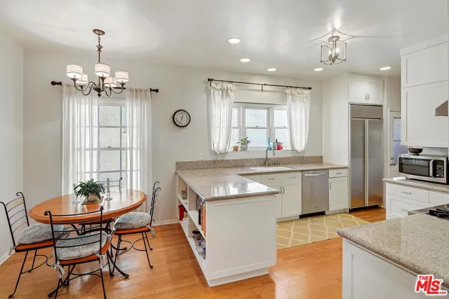 a kitchen with stainless steel appliances granite countertop a sink stove and refrigerator with wooden floor