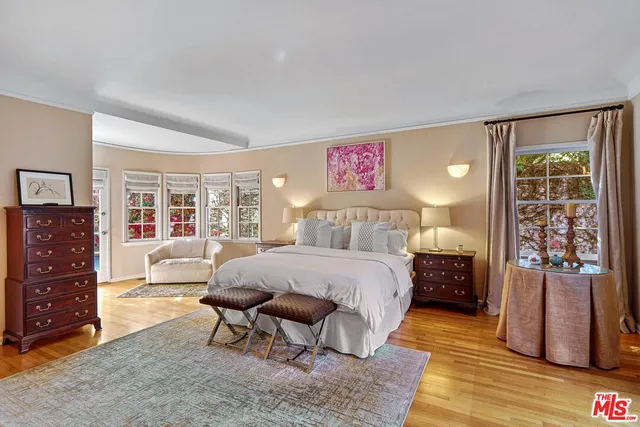 a spacious bedroom with a bed and dresser