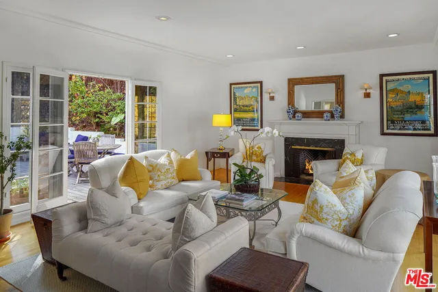 a living room with furniture fireplace and a large window