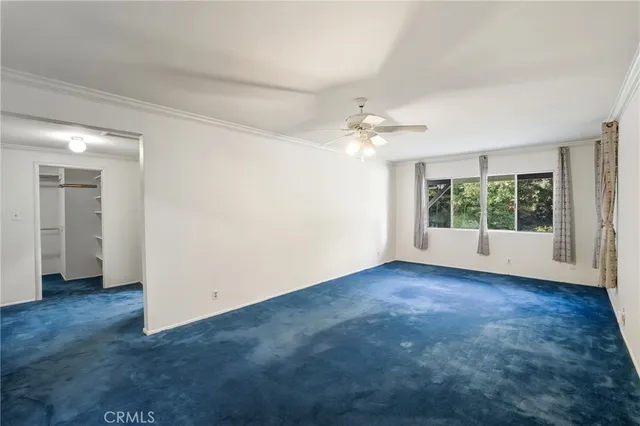 an empty room with wooden floor chandelier and windows