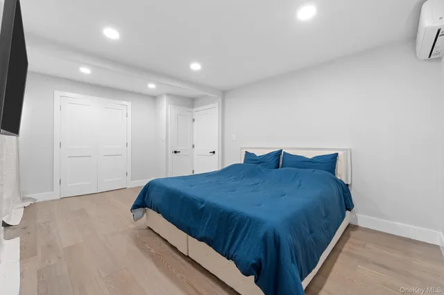 a spacious bedroom with a bed and a flat screen tv