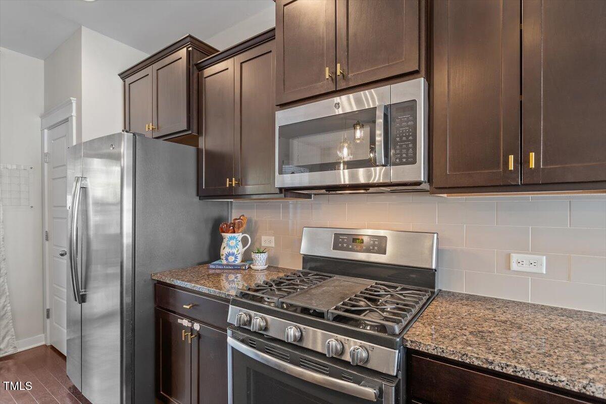 7822 Allscott Way Raleigh, NC 27612 - Photo 18 of 33 a kitchen with stainless steel appliances granite countertop a stove microwave and sink