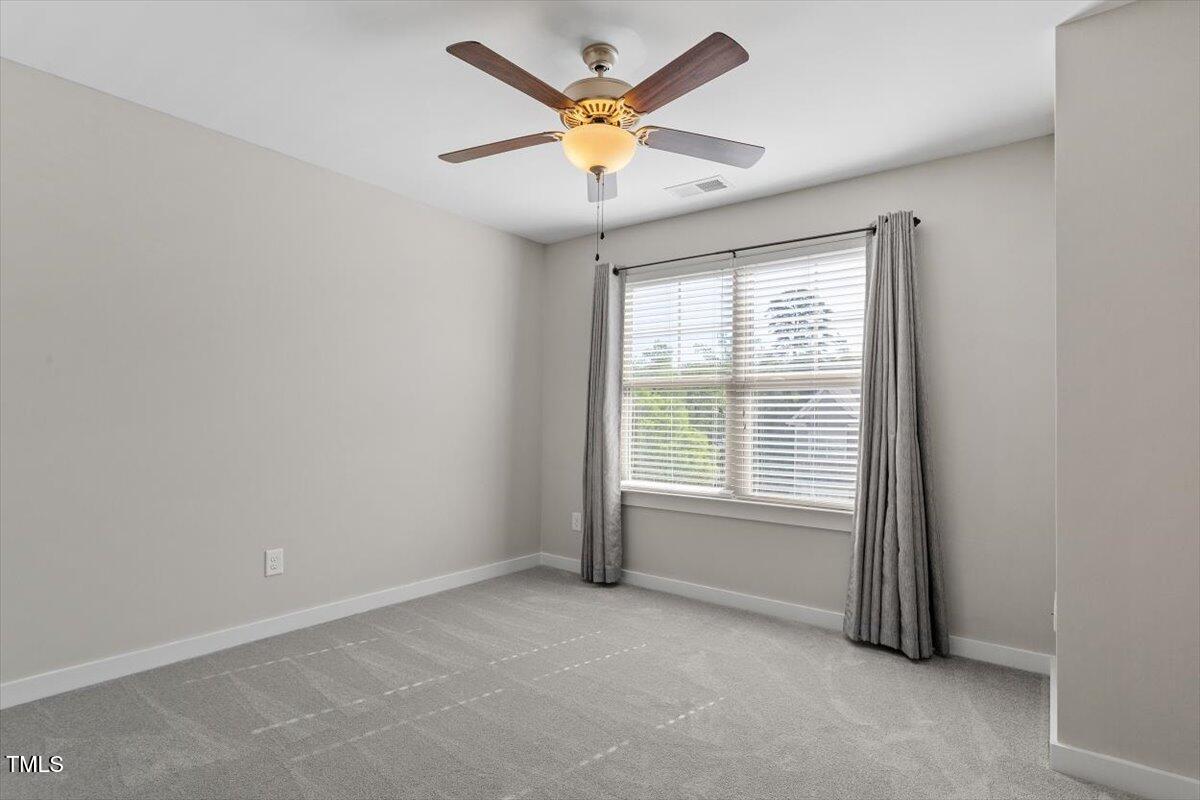 7822 Allscott Way Raleigh, NC 27612 - Photo 23 of 33 an empty room with a window and a ceiling fan