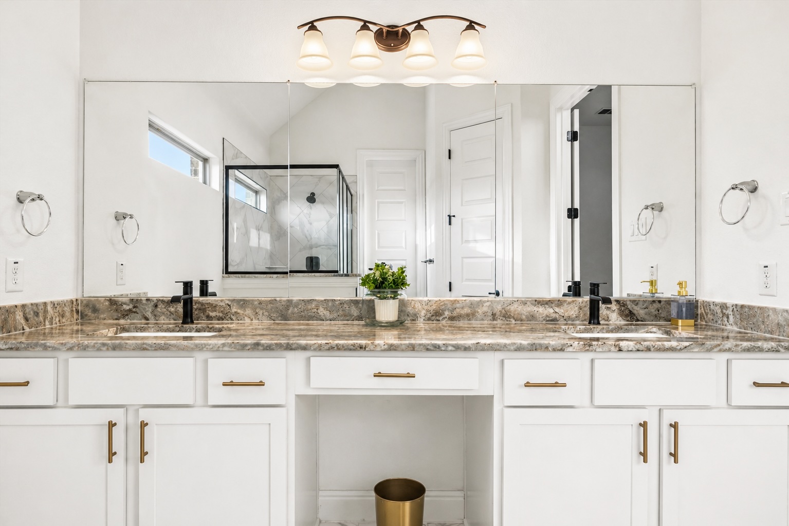 209 Rainier Drive Kyle, TX 78640 - Photo 12 of 24 Dual vanity with marble countertop, white cabinetry with brass-finish hardware, and matte black fixtures