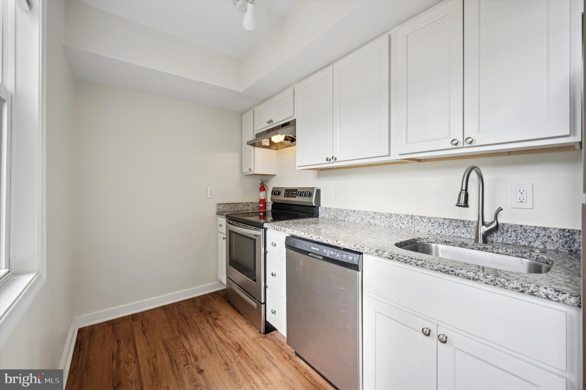 237 Roxborough Avenue, Unit 2 Philadelphia, PA 19128 - Photo 14 of 19 a kitchen with granite countertop white cabinets and white appliances
