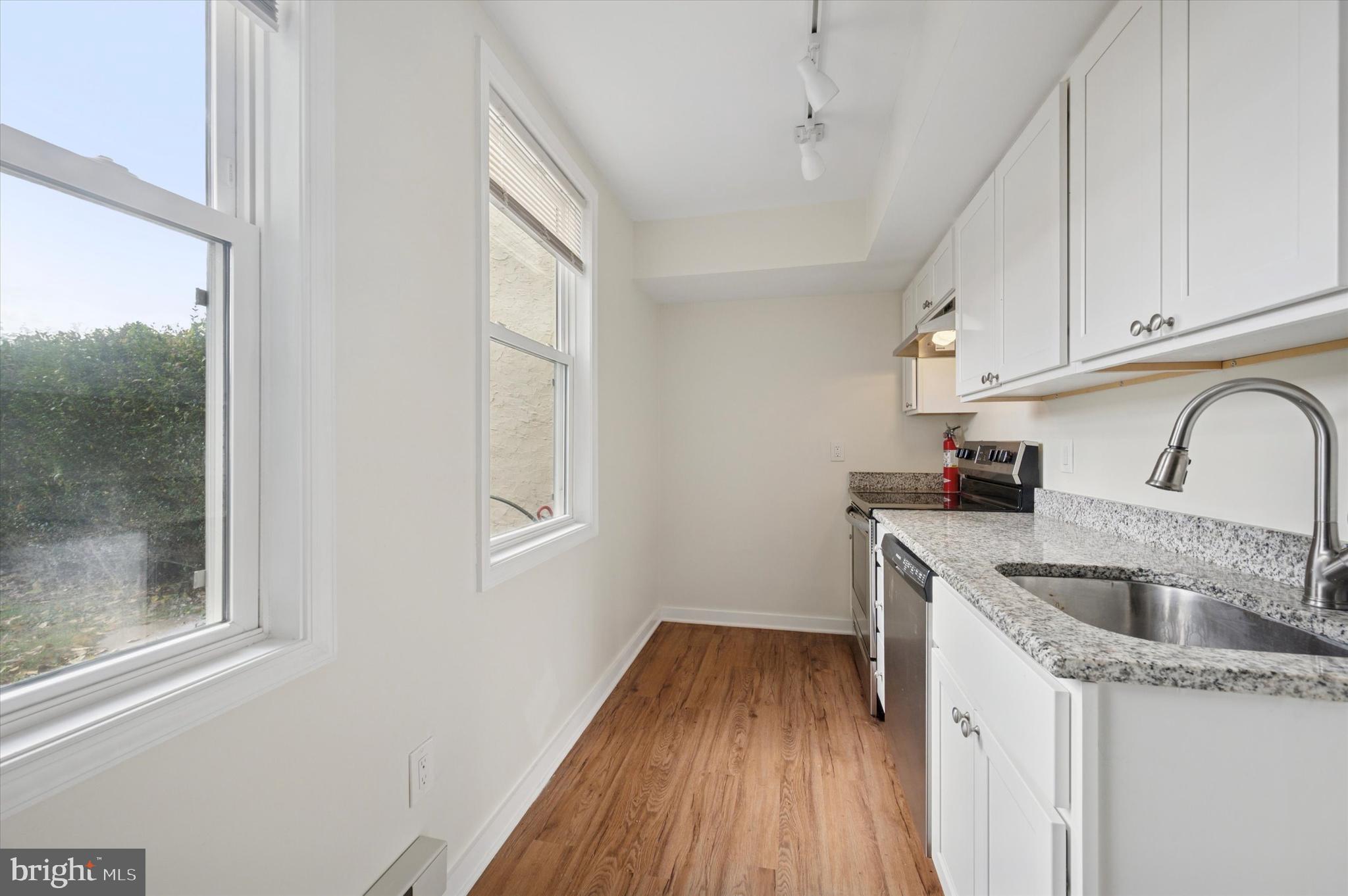 237 Roxborough Avenue, Unit 2 Philadelphia, PA 19128 - Photo 16 of 19 a kitchen with a sink a refrigerator and cabinets