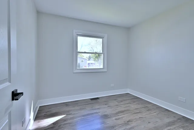 a view of a room that has wooden floor and window